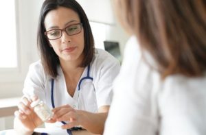 woman taking medication to assist with drug detox - extended medical detox concept image