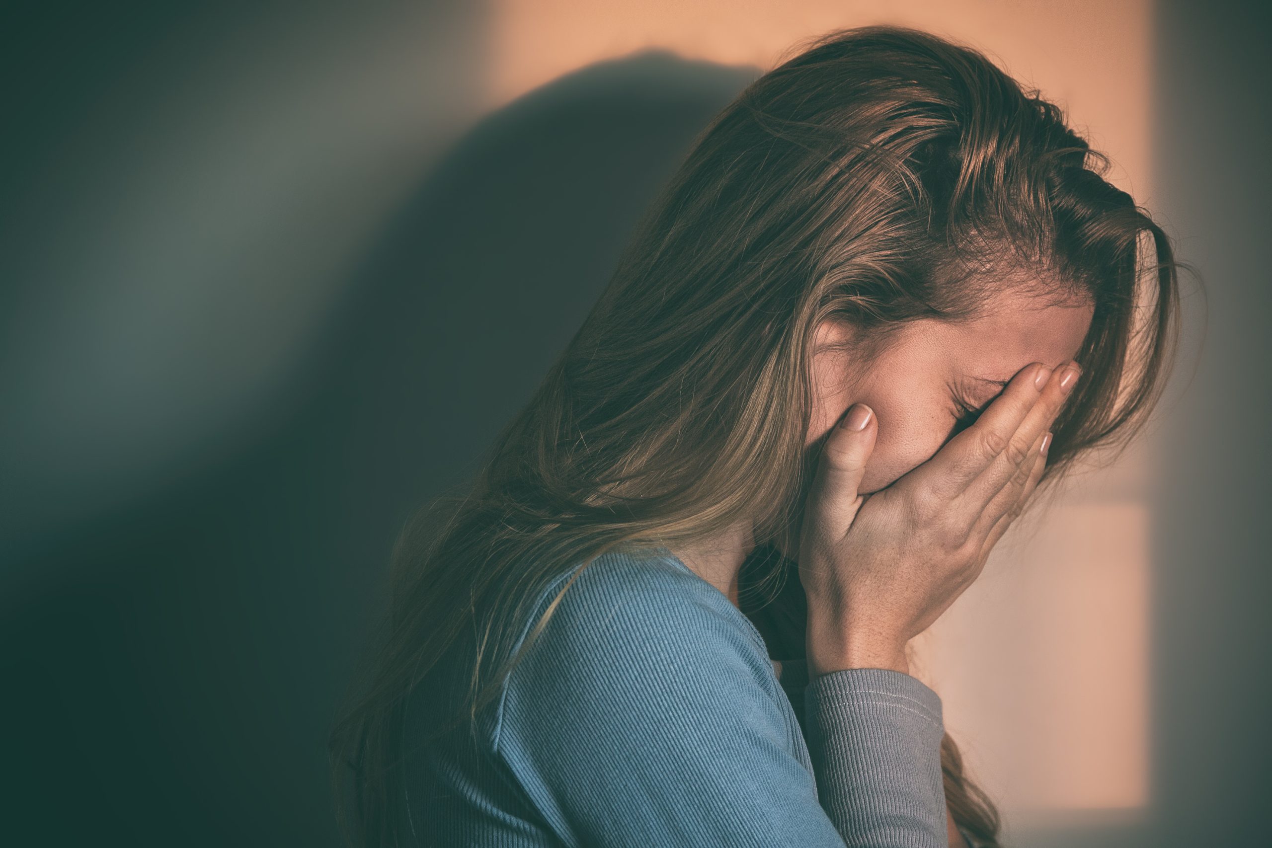 woman with her face in hand experiencing Guilt and Shame in Addiction