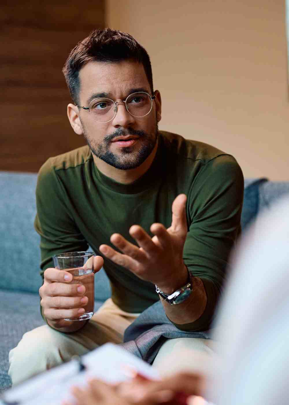 cbt-thought-patterns-discussion-addiction Man talking with a therapist during Cognitive Behavioral Therapy for addiction recovery.