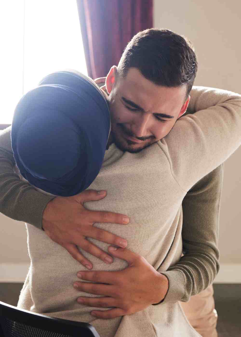 emotional-support-cbt-addiction-recovery Man hugging a loved one while receiving support through Cognitive Behavioral Therapy for addiction recovery.
