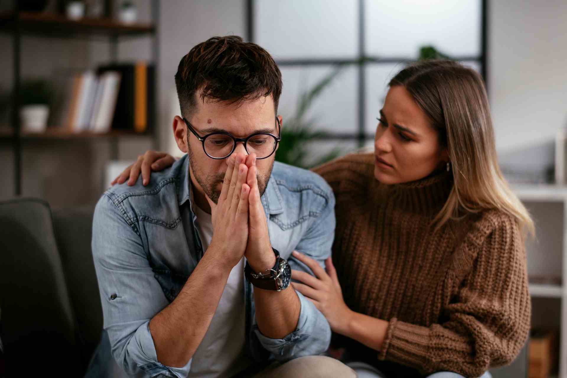 family-support-paying-for-addiction-treatment Worried man receiving support from a loved one while thinking about paying for addiction treatment
