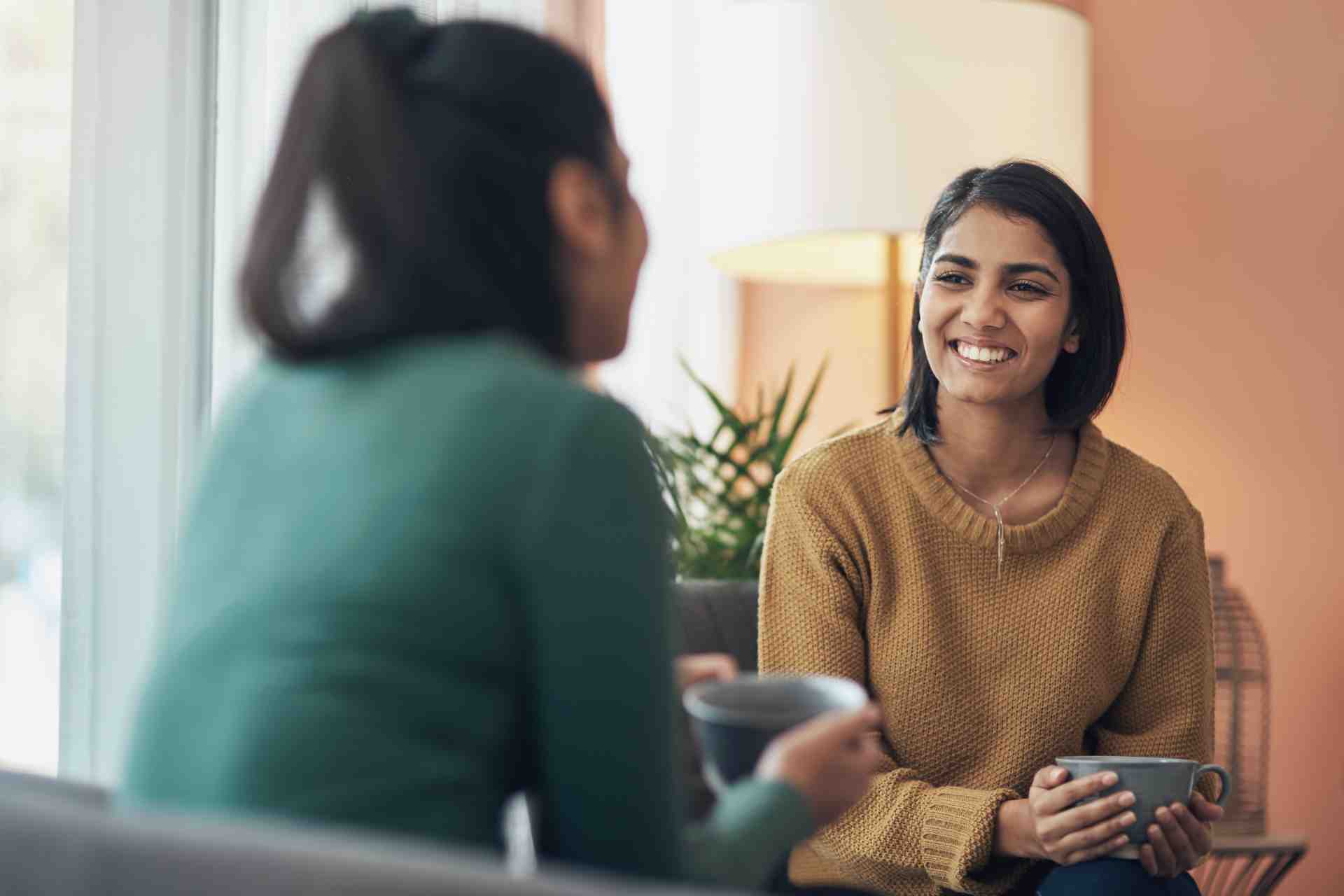 supportive-conversation-rehab Two women having a supportive conversation in a comfortable indoor setting about treatment and recovery