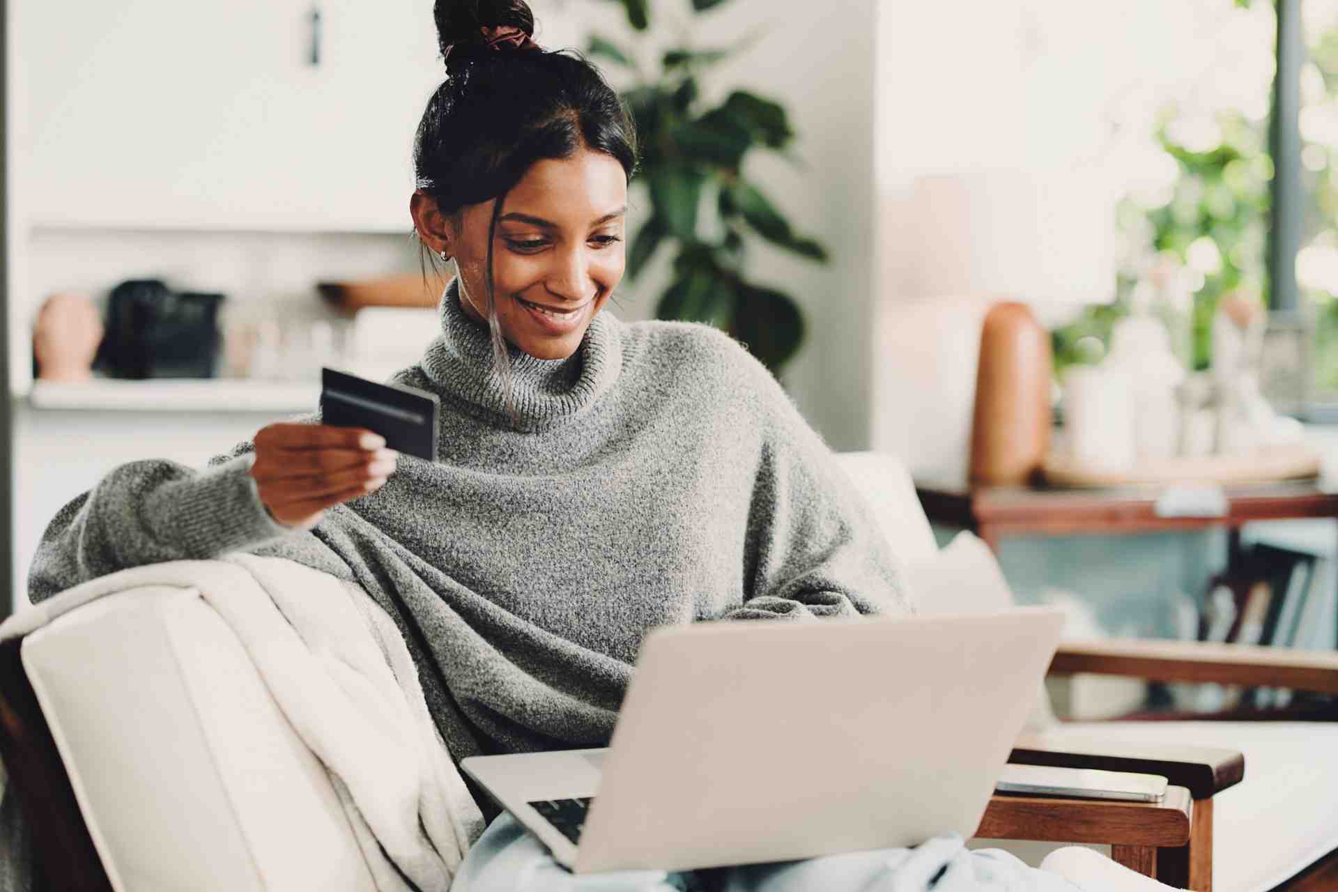 woman-paying-for-addiction-treatment-online Woman using a laptop and credit card to pay for addiction treatment online