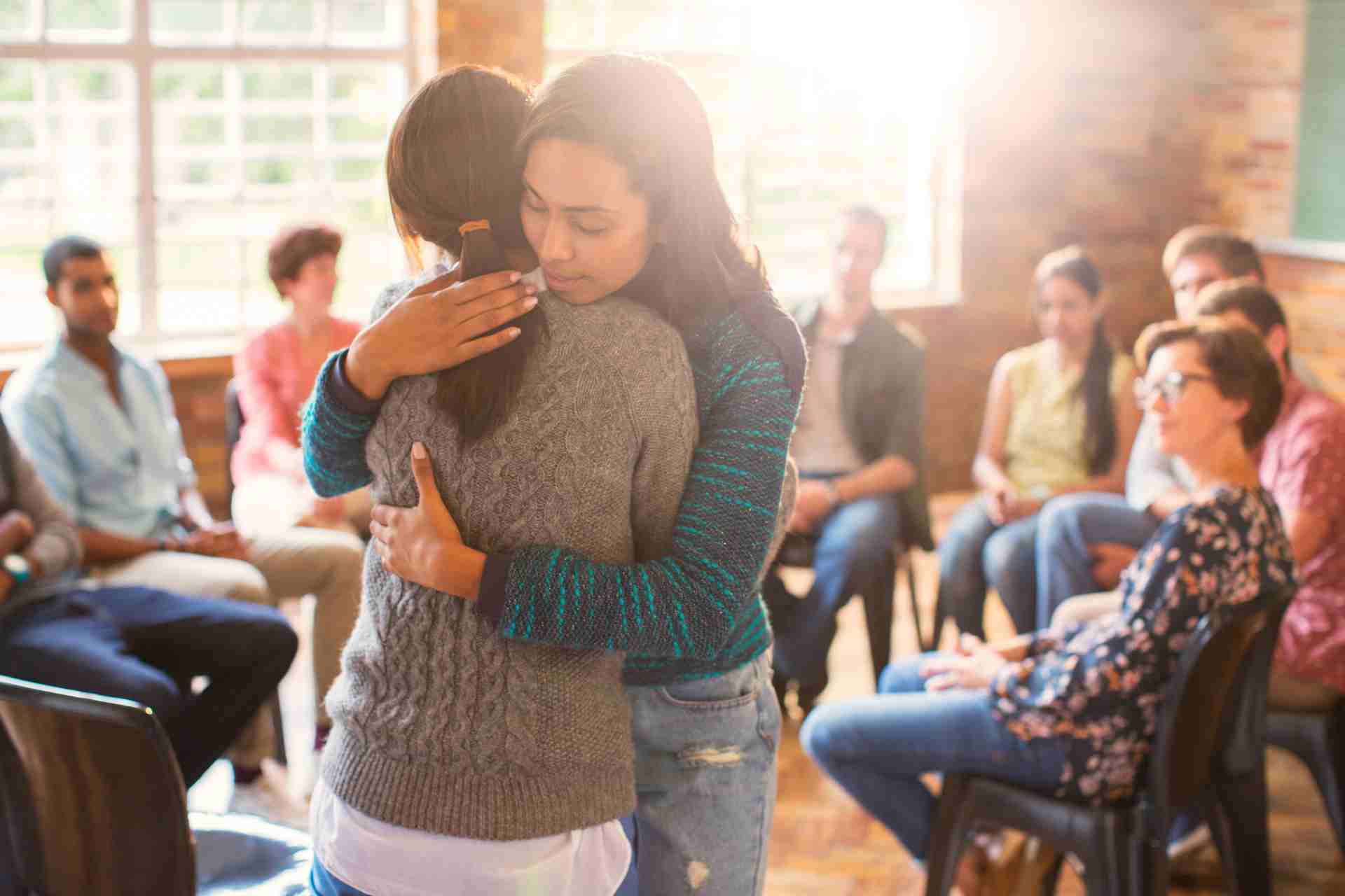 addiction-recovery-support-group-encouragement People embracing during addiction recovery support group session