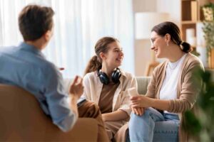 anxiety-disorders-treatment-pennsylvania-family-therapy Three individuals smiling and talking in family therapy for anxiety disorders