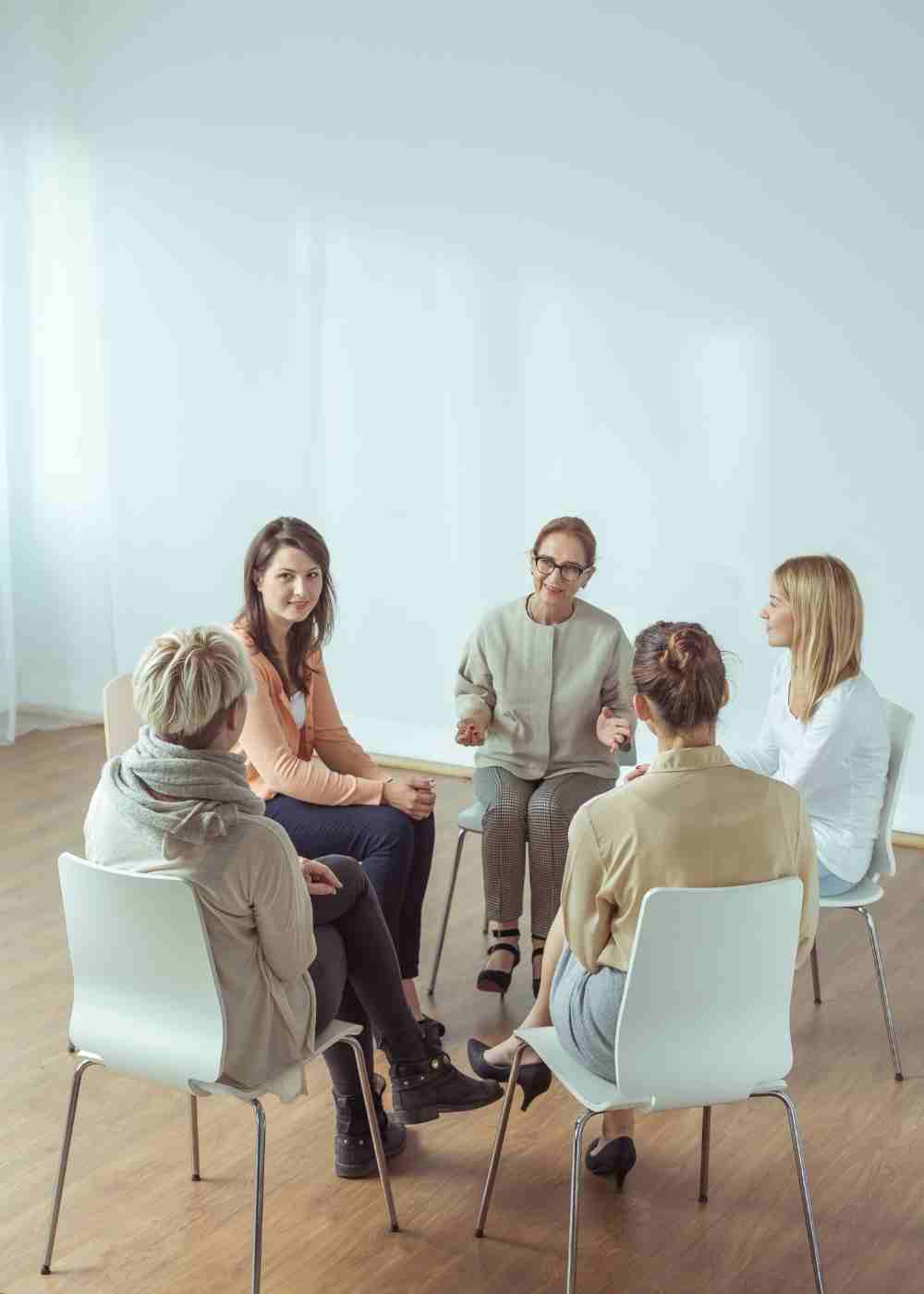 A family support group meeting where participants discuss how to help a loved one struggling with addiction.