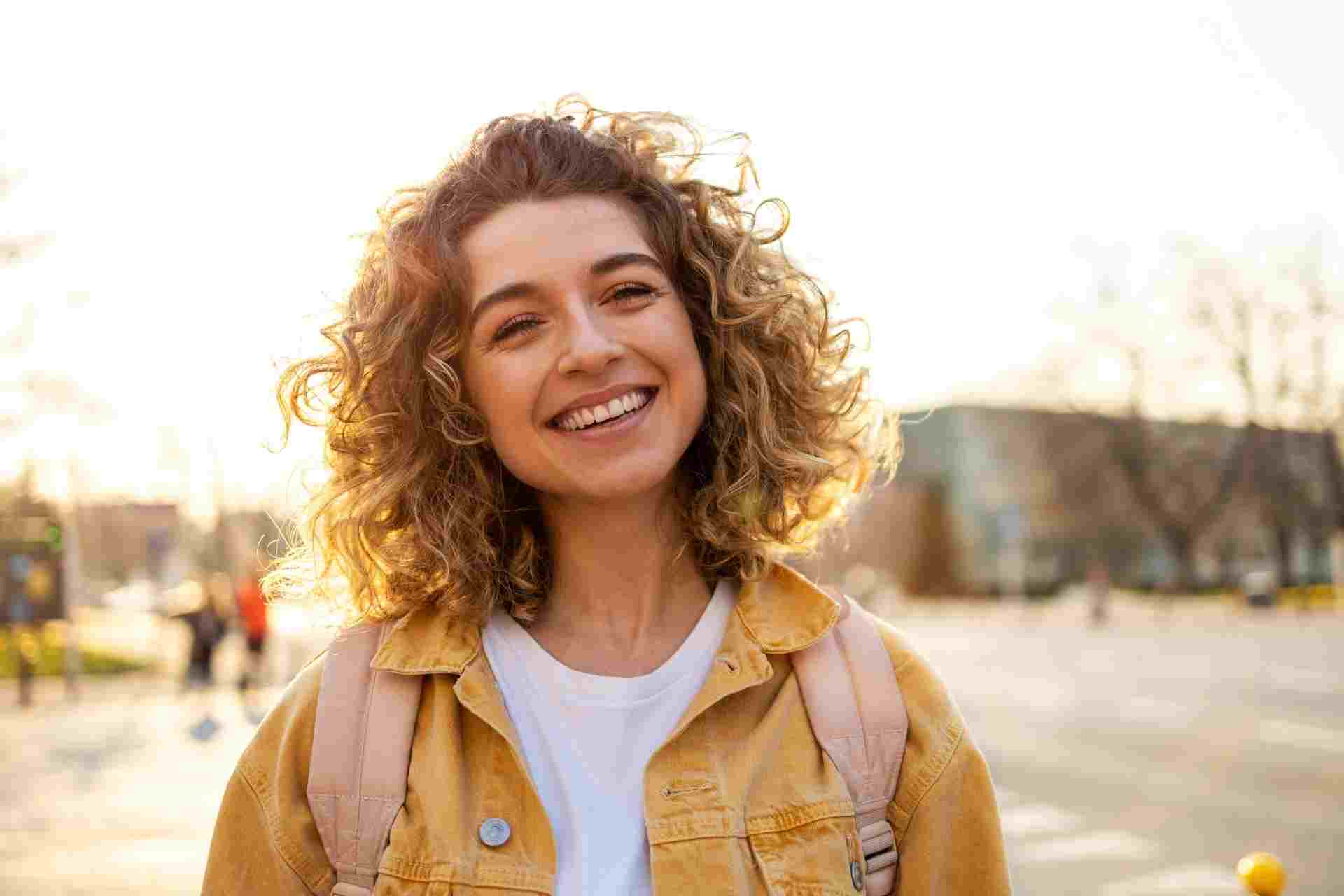 drug-detox-recovery Smiling woman outdoors representing renewed health and recovery after drug detox treatment.